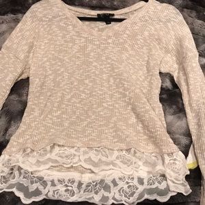 Cream colored blouse with flower detail on bottom
